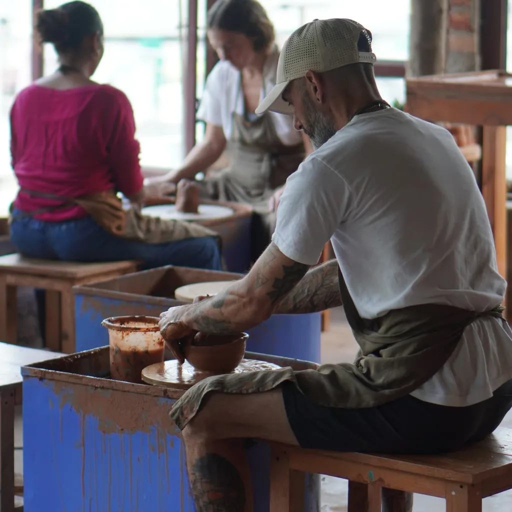 Guests throwing pots on the wheels during a pottery course