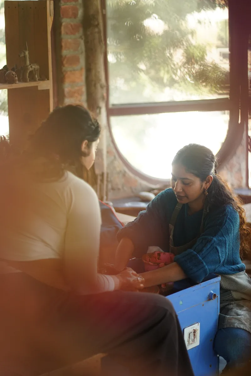 Shivani guiding a pottery student at Aavya
