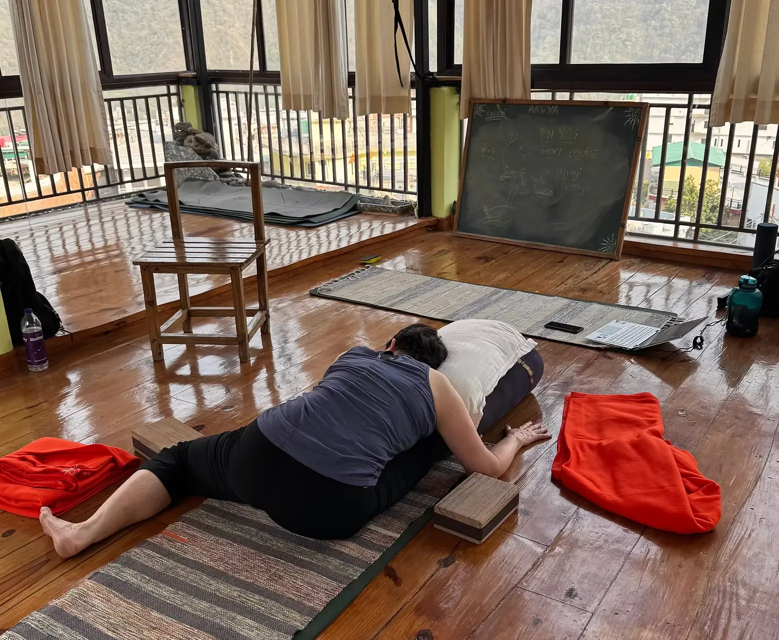 Student in a long supported Yin Yoga hold at Aavya, Upper Tapovan Rishikesh