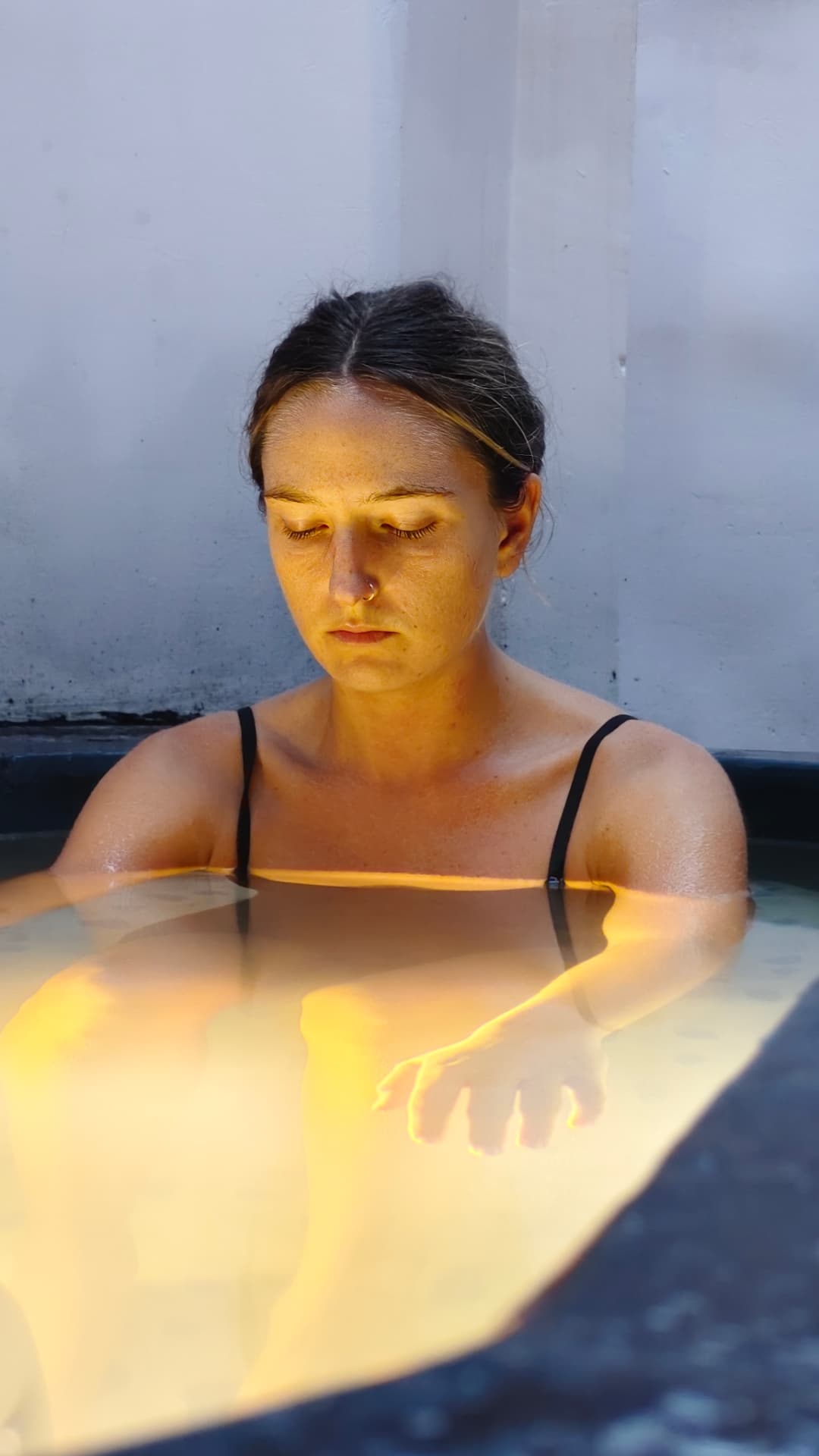 Guest settling into the ice bath before the cold plunge at Tapas