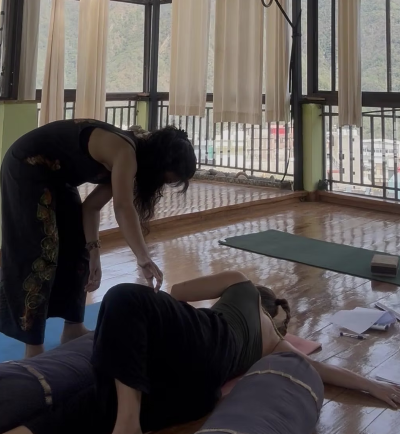 Dr. Rucha Shinde guiding a student through a supported Yin Yoga posture at Aavya, Rishikesh
