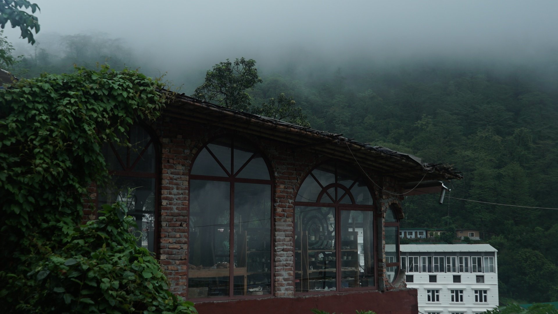 Aavya's brick and glass studio space wrapped in mist and rain during the monsoon