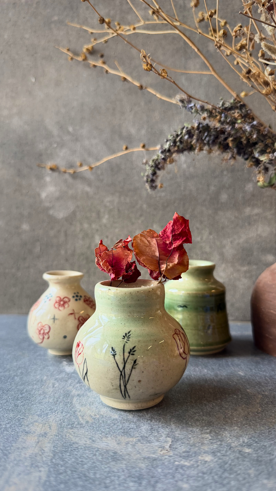 Collection of handmade ceramic vases with botanical illustrations from Aavya Pottery Studio, Rishikesh