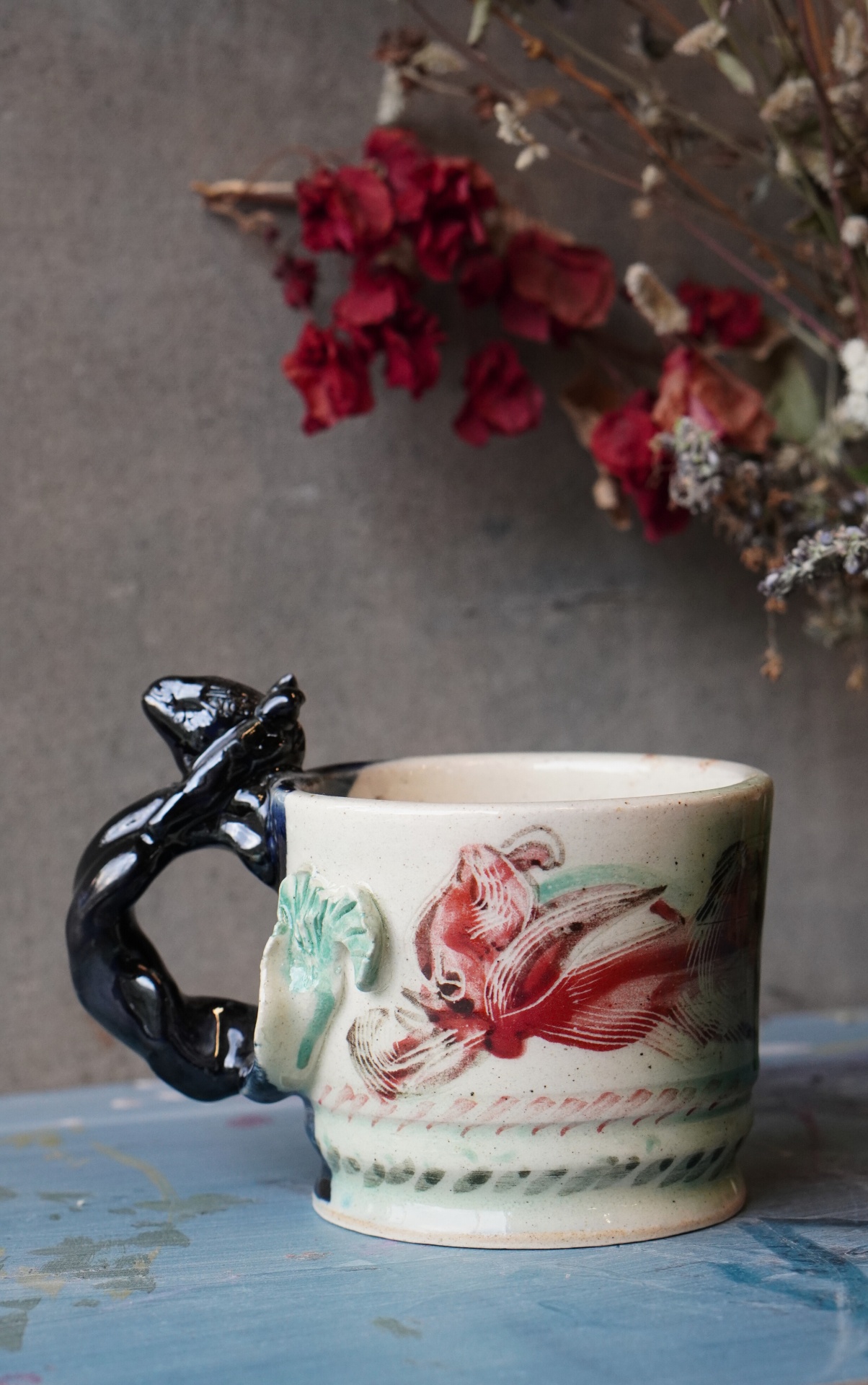 Handmade ceramic mug with floral design and sculpted handle from Aavya Pottery Studio, Rishikesh