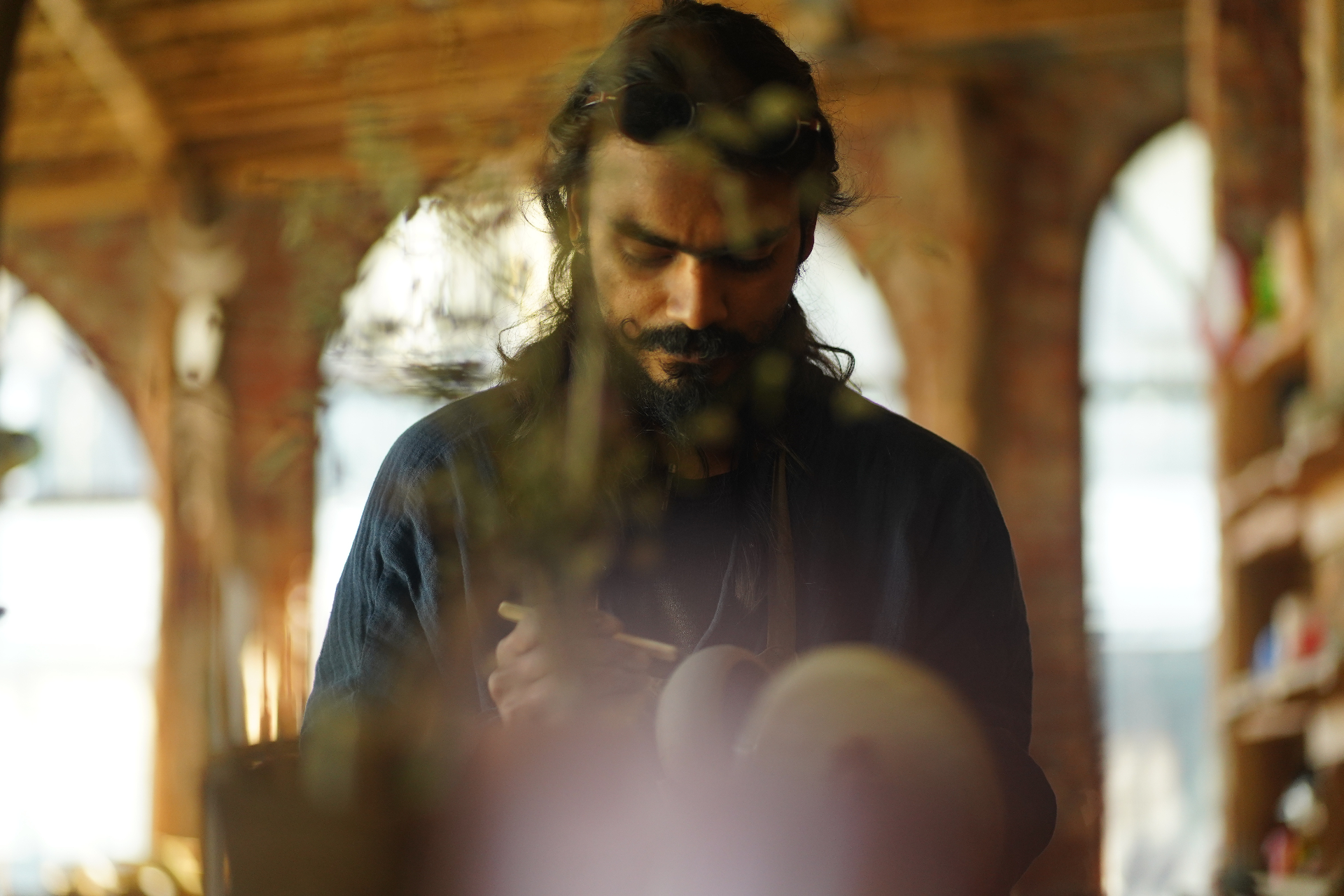 Artist working with clay in golden light at the Aavya pottery studio
