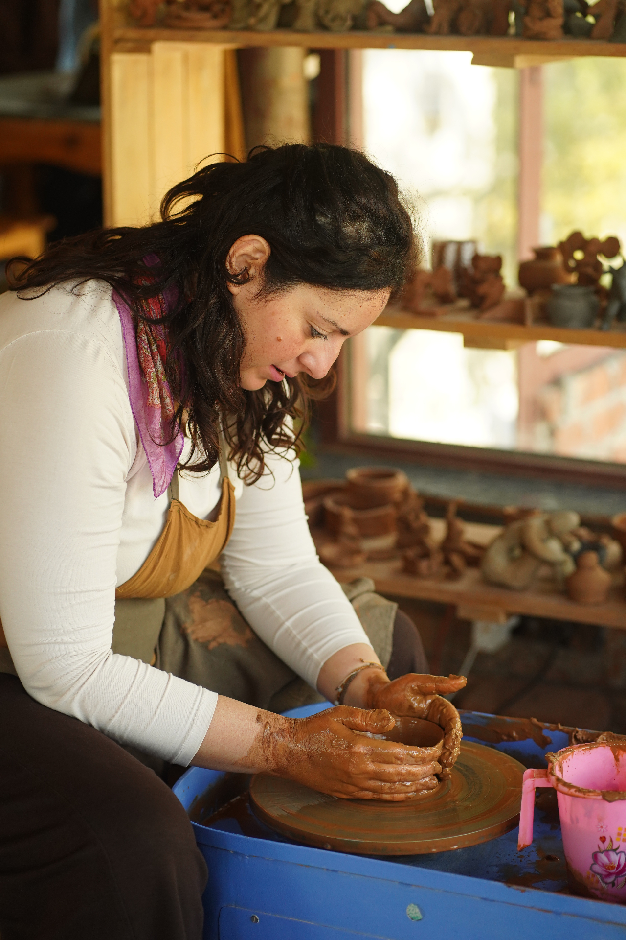 Guest throwing clay on the pottery wheel during a single session at Aavya studio